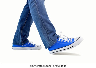 Close Up Of Steps Of A Person Walking With Sneakers And Jeans Isolated On White Background