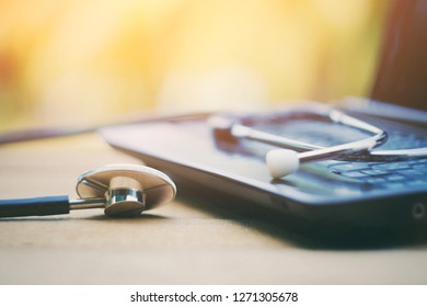 close up stethoscope and computer on old wood table, world health day, medical and healthcare business technology concept, vintage tone