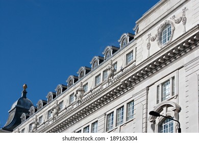 Close Up Still Life Detail View Of An Old Stone Building With Intricate Decorative Detail In The City Of London Standing On A Bright Blue Sky. Classic Architecture Perspective Diagonal Background.