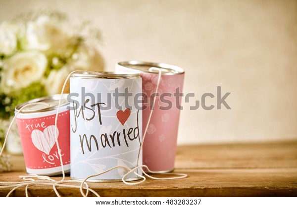 Close Up\
Still Life of Tin Cans Decorated with Congratulatory Messages and\
Tied with String for Dragging Behind a Car Following Wedding,\
Resting on Rustic Wooden Table with Copy\
Space