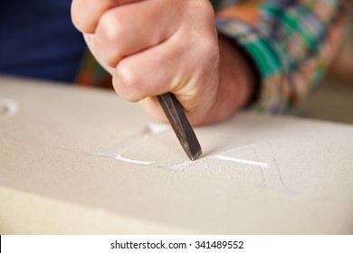 Close Up Of Stone Mason At Work On Carving In Studio