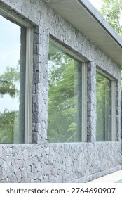Close up of stone wall with large window and modern building texture