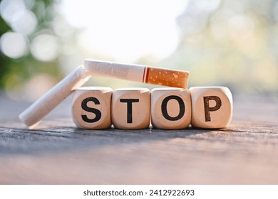close up stop wooden text block and cigarette on wood table, medical and healthcare, stop smoking, 31 may world no tobacco day concept