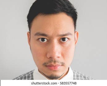 Close Up Of Straight Face Of Serious Asian Man With Light Beard.