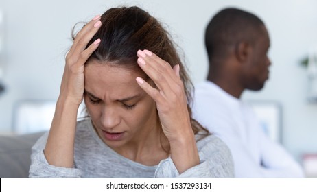 Close Up Of Stressed Young Wife Sit Separately Worried About Breakup Or Divorce, Avoid Talking With African American Husband After Fight, Anxious Multiethnic Couple Ignore Each Other, Consider Breakup