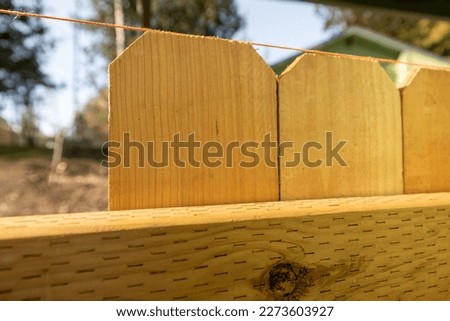 Close Up of String Spaced Along Top Portion of Wood Cedar Pickets on New Fence Build DIY Yard Improvement