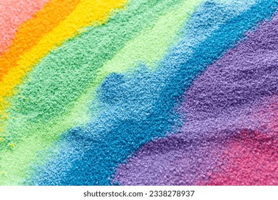 Close up of stripes of rainbow coloured sand and copy space background. Sand, texture, movement, shape and colour concept.