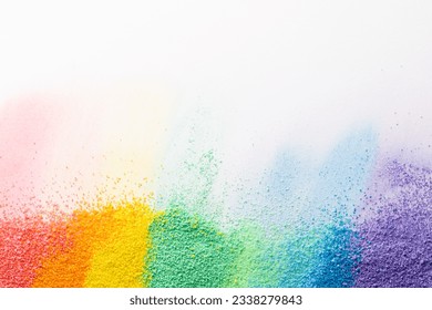 Close up of stripes of rainbow coloured sand and copy space on white background. Sand, texture, movement, shape and colour concept.