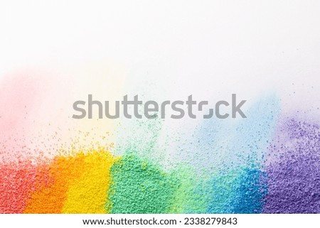 Close up of stripes of rainbow coloured sand and copy space on white background. Sand, texture, movement, shape and colour concept.