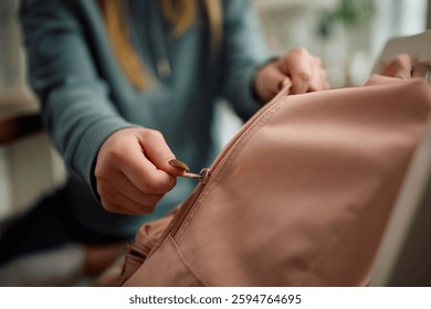 Close up of student closing her backpack after learning at home.
