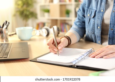 Close Up Of Student Girl Hand Writing On Notebook On A Desk At Home