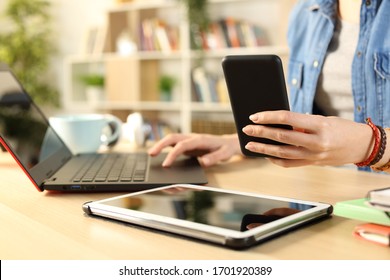 Close Up Of Student Girl Hands Using Multiple Devices Sitting On A Desk At Home