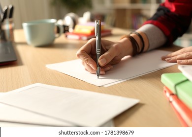 Close Up Of Student Hand Writing Letter On A Desk At Home In The Night