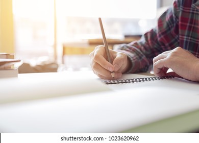 Close Up Student Hand Writing On Paper With A Pencil Taking A Test.