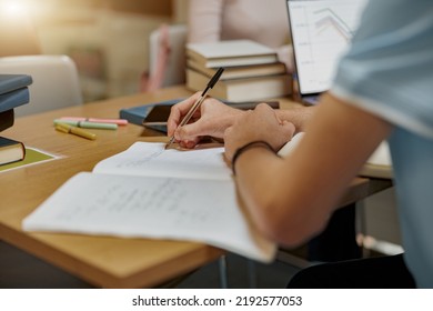 Close up of student sits in library, prepare for exam and making notes in notebook - Shutterstock ID 2192577053