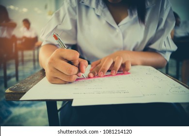 Close Up Students Writing And Reading Exam Answer Sheets Exercises In Classroom Of School With Stress.