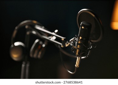 Close up of studio microphone with pop filter and headphones supporting podcast recording, livestream production, audio branding, content marketing, copy space