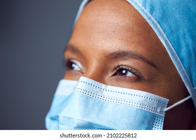 Close Up Studio Portrait Of Female Surgeon Wearing Scrubs And Face Mask