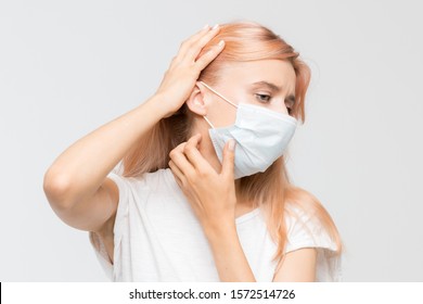 Close Up Studio Portrait Of Woman In White T-shirt With Medical Mask Who Scratching Itchy Throat. Irritation, Sensitive Dry Skin, Allergy Symptoms, Dermatitis, Insect Bites. Healthcare Concept.