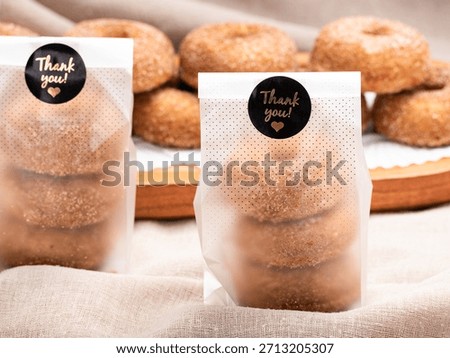 A close up studio shot of two clear gift bags full of cinnamon sugar doughnuts. Citron donuts.