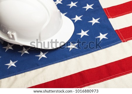 Close up studio shot of a white color construction helmet over USA flag