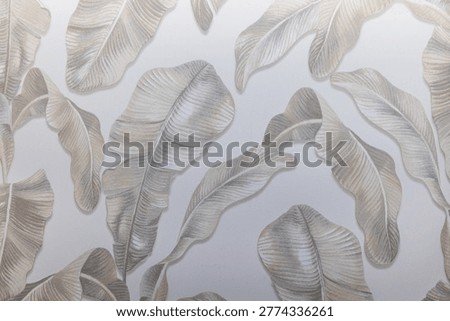 Close up of a subtle botanical wallcovering featuring soft grey and beige watercolor leaves on a light background.