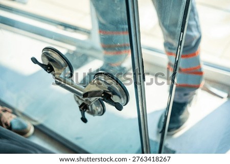 Close up of suction cup lifter attached to window glass used for safe handling during replacement process in apartment. Professional equipment for glass installation and repair work concept