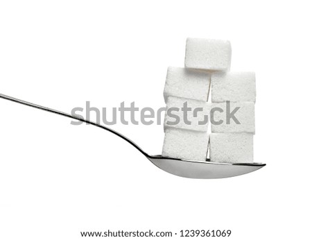 close up of  sugar cubes and a spoon on white background