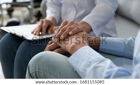 Close up of supportive female caregiver hold hand of mature grandmother visit patient at home, caring woman doctor support old senior grandma give consultation or help, elderly healthcare concept
