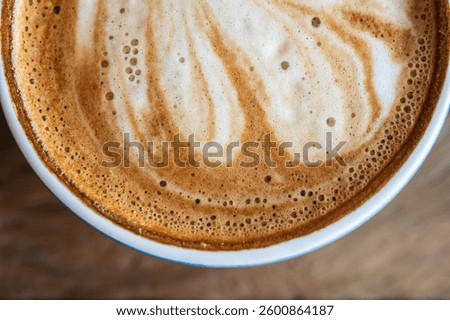 Close up of the surface of hot latte coffee. A latte is a coffee drink made with espresso and steamed milk.