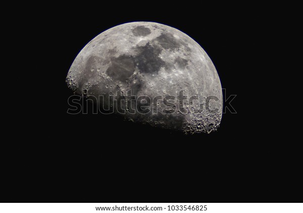 Close up\
of surface of the Moon on black\
background.