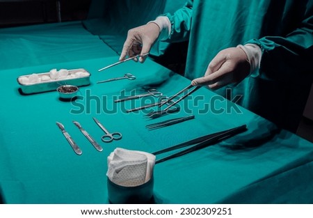 Close up surgeon doctor's hand with hygiene glove taking sterile surgical instrument tool, equipment in operating room. Hospital, medical healthcare emergency concept