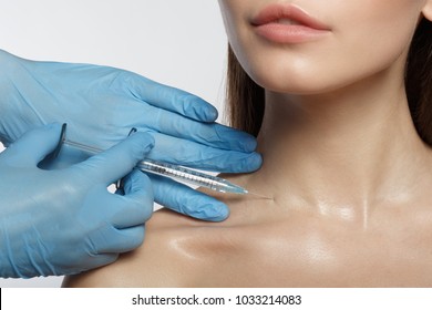 Close up of surgeon hands in glove injecting rejuvenating liquid into female neck. Beauty concept