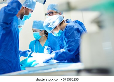 Close up of surgery team operating  - Shutterstock ID 573583255