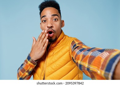 Close Up Surprised Young Black Man 20s Years Old Wears Yellow Waistcoat Shirt Doing Selfie Shot Pov On Mobile Phone Cover Mouth With Hand Isolated On Plain Pastel Light Blue Background Studio Portrait