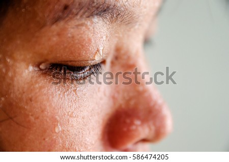 Close up sweating water drop on eyes asian woman. focus sweat on eyes. Sport female exercise in fitness.