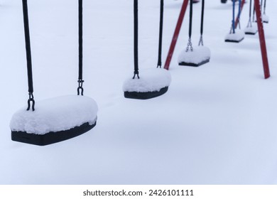 Close up of swings covered in snow at the empty playground in winter. Finland. - Powered by Shutterstock