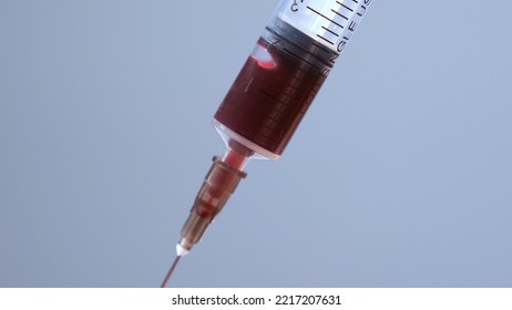 Close Up Of A Syringe Drawing Blood. Syringe And Blood