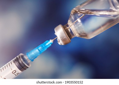 Close up syringe of vaccine medication needle, concept, hospital care prevention, dysfocal image, immunization illnesses. blue