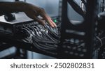 Close up of system administrator connecting cables with server rack, working in server room. Maintenance of LAN or web servers. Operation of information systems and networks. Data storage center.