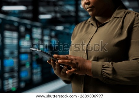 Close up of system administrator using tablet in data center to track metrics of gear used to host websites. Server room IT specialist upgrading capacity of storage rigs running companies databases