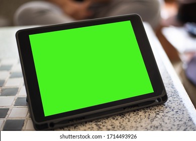 Close up tablet green screen on table technology concept.