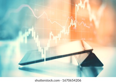 Close up of tablet on desktop with abstract forex chart hologram. Analytics and trade concept. Multiexposure
