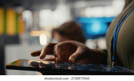Close up of tablet used by programmer in office to accelerate complex artificial intelligence calculations. IT employee using touchscreen device to train deep learning datasets systems, camera A