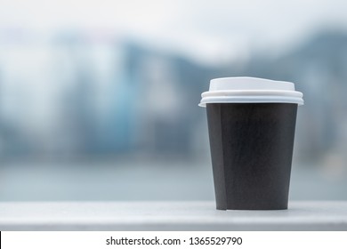 CLose up of take away paper cup of hot coffee with nature background and copy space.