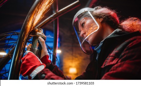 Close Up of a Talented Innovative Tomboy Female Artist Using an Angle Grinder to Make Abstract, Brutal and Expressive Metal Sculpture in a Workshop. Contemporary Fabricator Creating Modern Steel Art. - Powered by Shutterstock