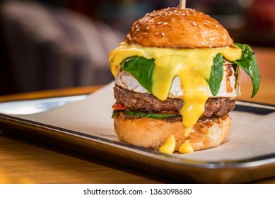 Close Up Tall Tasty Burger With Cheese Served On Tray