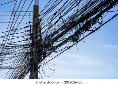 A Close Up Of Tangled Electrical Wires And Cables With Blue Sky