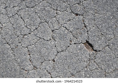 close up tarmac road with crack and hole, top view of damaged asphalt road surface