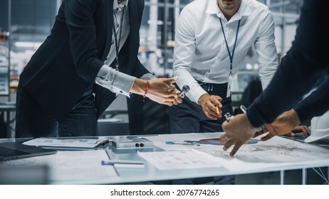 Close Up Of A Team Of Automotive Engineers Working In Office At Car Factory. Industrial Designer Talks About Electric Engine Parts With Colleagues, Discussing Different Technological Applications.